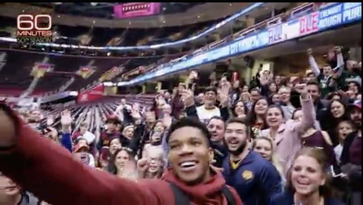 Giannis Antetokounmpo taking a selfie with fans.